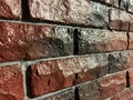 Red-blue brick wall covered with glossy lacquer with embroidery