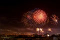 Red blue bright firework in the night sky over a city. Townspeople celebrating the New Year and launching fireworks at midnight.