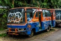 Red-blue Bus wrackage abandoned on side the street photo taken in Jakarta Indonesia