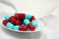 Red and blue capsules on plastic spoon fork Royalty Free Stock Photo