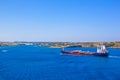 Red /blue cargo ship goes along the coast of Menorca, Spain Royalty Free Stock Photo