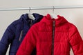 Red and blue child down jackets hanging