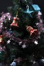 The red and blue Christmas-tree decorations hanging on branches among brilliant tinsel.