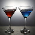 Red and blue cocktails in Martini glasses.