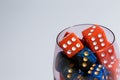 Red and blue dice in a glass. Many dice of different colors in a glass glass. Copyspace Royalty Free Stock Photo