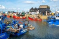 Red and blue fishing boats docked at Whitstable Harbour, Kent. Royalty Free Stock Photo