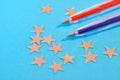 Red and blue fountain pens lie next to the silver stars on a blue background. The problem of brexit. Grade system at school.