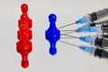 Red and blue game pawn and injection needles Royalty Free Stock Photo
