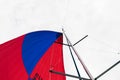 The red and blue gennaker of a sailing yacht catches the wind in an open state. Royalty Free Stock Photo