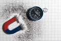 Red and blue horseshoe magnet or physics magnetic and compass with iron powder magnetic field on white paper graph background. Royalty Free Stock Photo