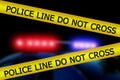 Red and blue lights of police car. Yellow police tape with text: police line do not cross. Scene of an accident or crime Royalty Free Stock Photo