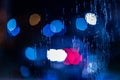 An abstract background of red and blue police lights bokeh trough wet glass at night close-up with selective focus Royalty Free Stock Photo