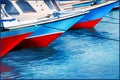 Red and blue old fishing boats in the seaport. Colored reflections in the water. Sea background.