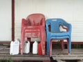 Red and blue old plastic chair storage, White plastic jerry can in tropical environment. Caribbean culture