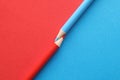 Red-blue pencils pointed towards each other on red-blue background Royalty Free Stock Photo
