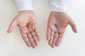 a red and blue pill in a man& x27;s hand. The concept of choosing treatment and medicine. Hand taking medicine capsule Royalty Free Stock Photo