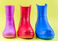 Red blue and pink rubber boots EVA on a yellow background Royalty Free Stock Photo