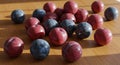 Red And Blue Plums On Wooden Table In Sunlight Royalty Free Stock Photo