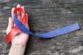 Red and Blue ribbon awareness on woman human hand aged wood for Congenital Heart Defects disease Royalty Free Stock Photo