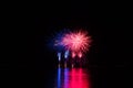 Red and blue rich stars from fireworks over surface of Brno`s Dam with reflection on the surface of lake Royalty Free Stock Photo