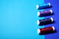 Red and blue sewing threads on double-colored background. Royalty Free Stock Photo