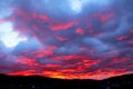 Red-blue sunset over the city is covered with clouds. City silhouette with a beautiful sunset. Artistically blurred Royalty Free Stock Photo