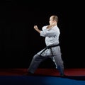 On red and blue tatami active athlete trains formal karate exercises