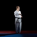 On red and blue tatami adult athlete doing formal karate exercises