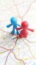 A red and blue toy couple standing on Valladolid on a map of Spain portrait