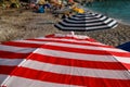 Red, blue and white sun umbrella for sunbathing and protection of sun rays, closeup. Colorful parasol beach umbrella.