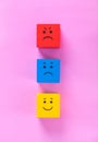 Cubes with cute faces depicting human emotions: anger, sadness and happiness