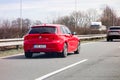 Red BMW 120i (1-Series) overtaking in left lane with motion blur effect