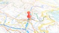 A red board pin stuck in Udine on a map of Italy