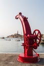 Red boat crane arches over Rovinj