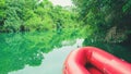 Red inflatable boat and the green waters of Formoso river