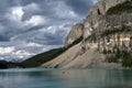 Red boat in turquoise lake with mountains. Royalty Free Stock Photo