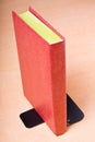 Red book leaning on bookend