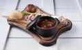 Red borsch soup in a small saucepan placed on white boards Royalty Free Stock Photo
