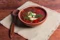 Red borscht in bowl on rustic table lightened from left Royalty Free Stock Photo