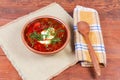 Red borscht in bowl and wooden spoon on rustic table Royalty Free Stock Photo