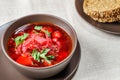 Red borscht soup in brown bowl top view, on white tablecloth. Royalty Free Stock Photo