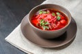 Red borscht soup in brown bowl top view, on white tablecloth. Royalty Free Stock Photo