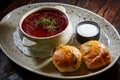 Red borscht with sour cream, wild garlic, bread on a wooden background