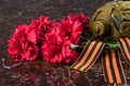 Red bouquet of flowers with a military jar and festive ribbons, on the background of marble