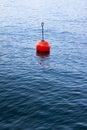 Red bouy on a calm lake isolated on blue background Royalty Free Stock Photo