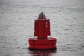 Red bouy on the Nieuwe Waterweg at the harbor of Rotterdam to mark the shipping route.