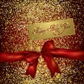 Red bow and new year greeting card on a gold glittery background