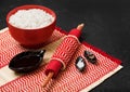 Red bowl with boiled organic basmati jasmine rice with wooden chopsticks and sweet soy sauce on bamboo placemat with red linen Royalty Free Stock Photo