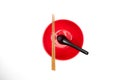 Red bowl with chopsticks and spoon on a white background. Top view Royalty Free Stock Photo