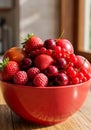 Red Bowl of Summer Berries and Fruit on Wooden Table Royalty Free Stock Photo